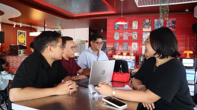 Team members working on laptops at the diner counter