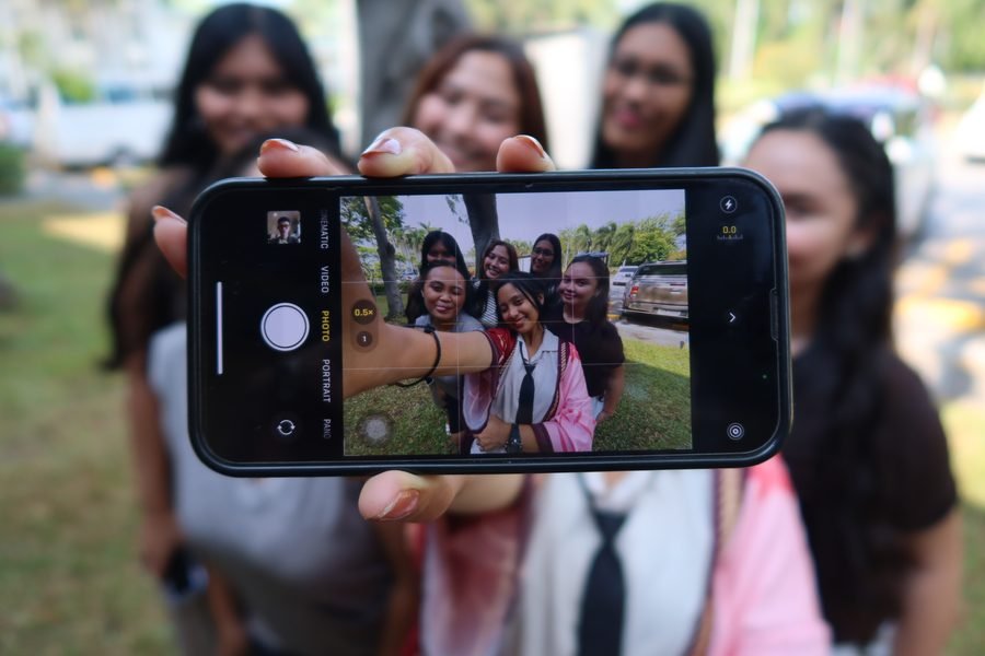 Team members capturing a group photo on a phone